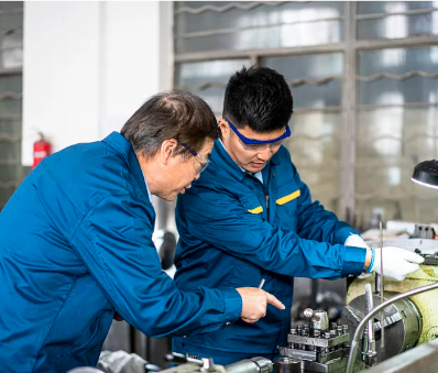 Henan Mingtan technician guiding a young worker at the machining workshop